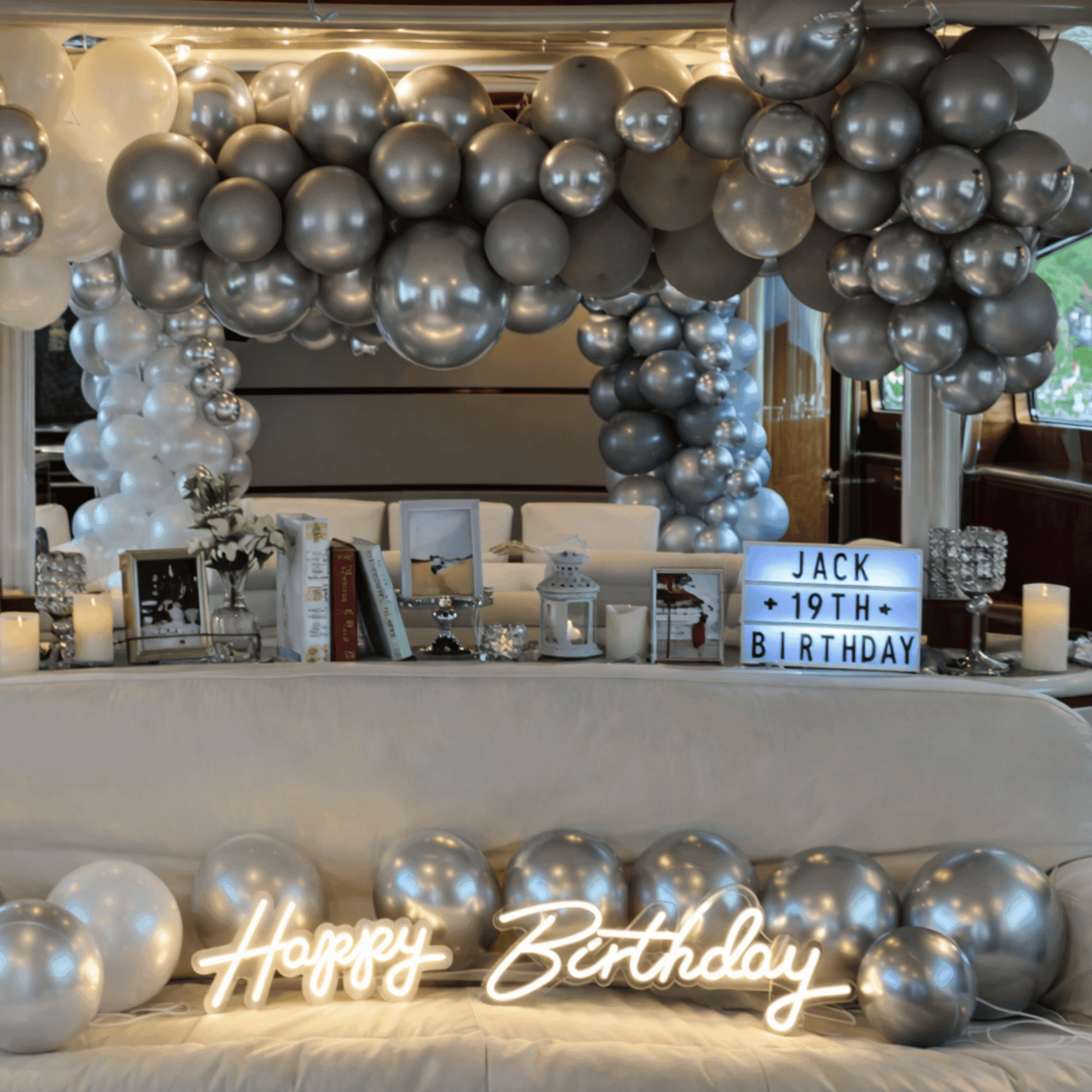 Silver balloon arch birthday setup on yacht