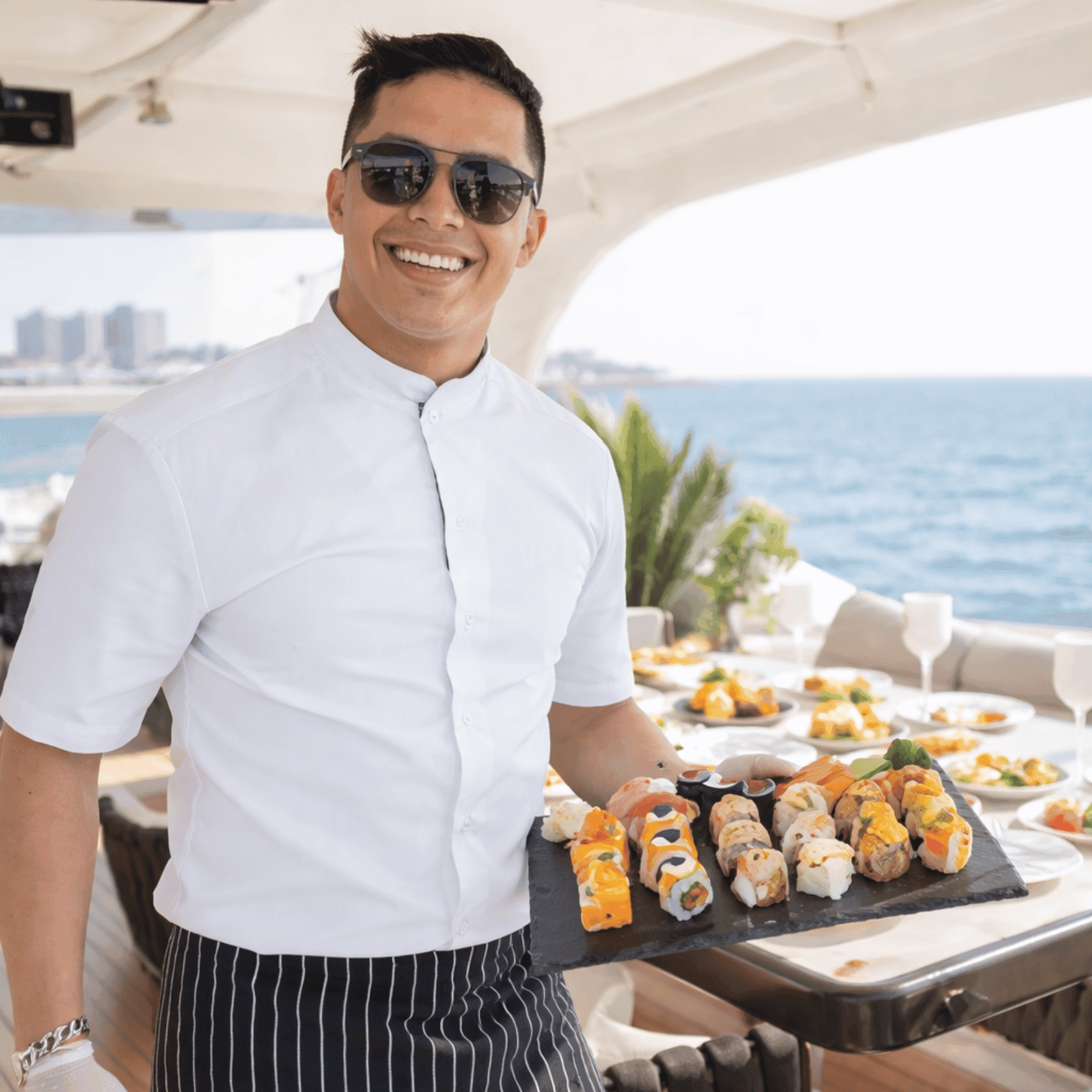 Chef presenting sushi platter on yacht deck